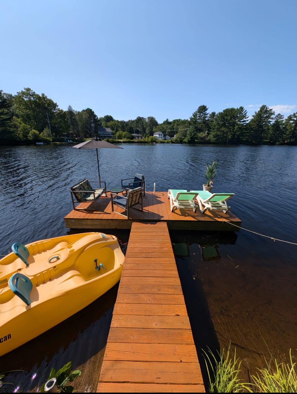 Private dock with lounge chairs and pedal boat on the Muskoka River at The Muskoka River Chalet
