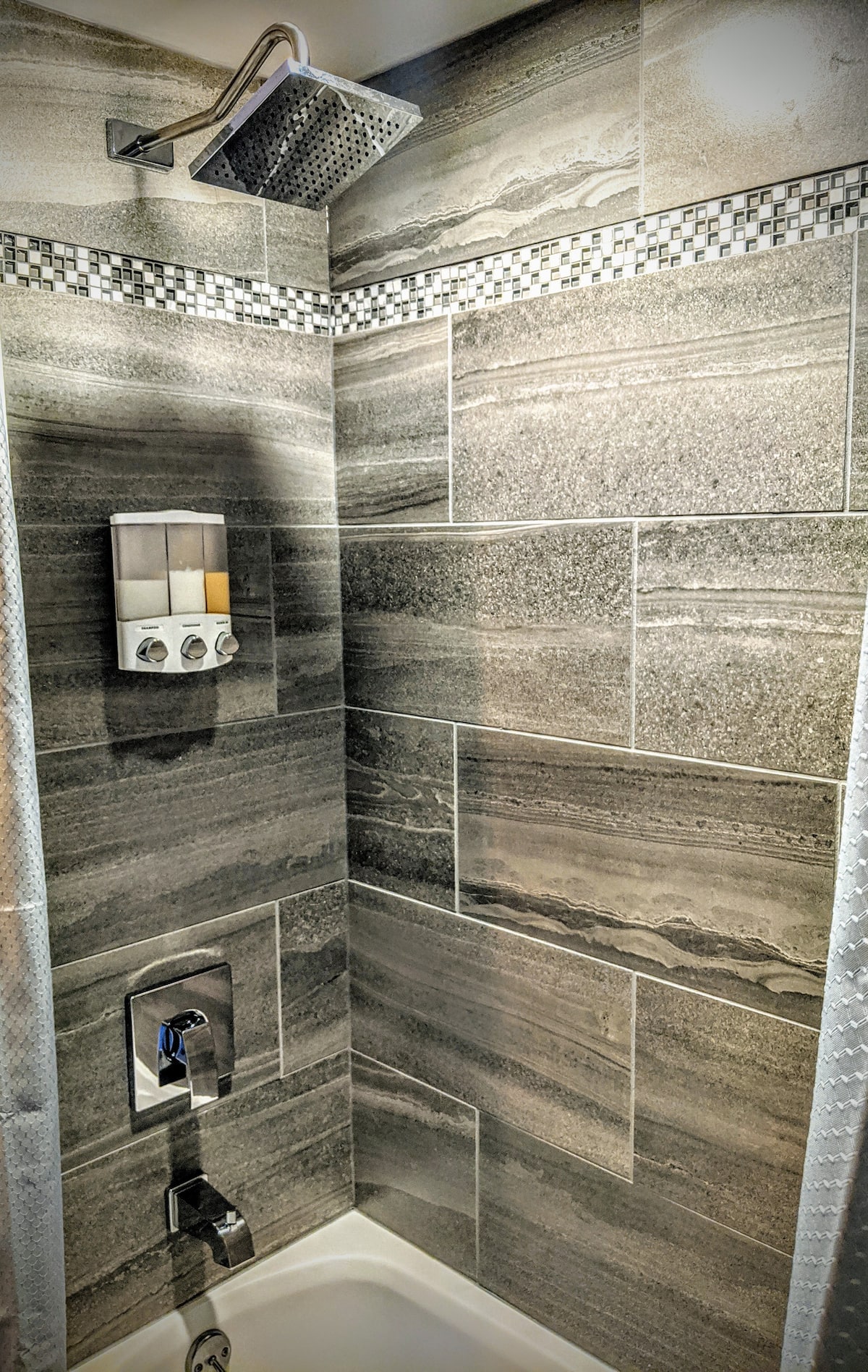 Modern tiled shower with rain showerhead at The Muskoka River Chalet